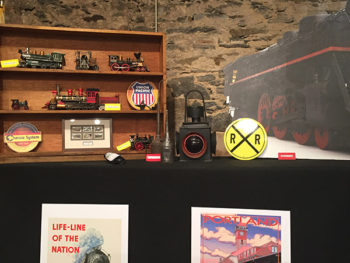 Train memorabilia with posters, old railroad signs, and model trains