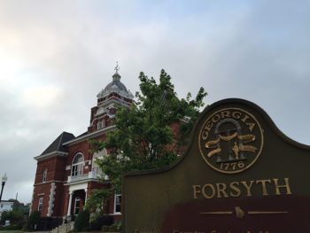 Angled shot of the Forsyth courthouse and city sign